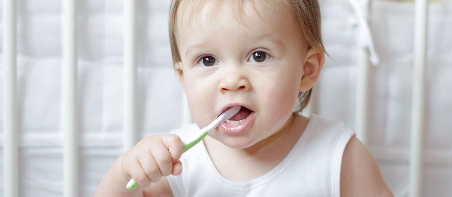 بنت صغيرة معها فرشاة اسنان خضراء